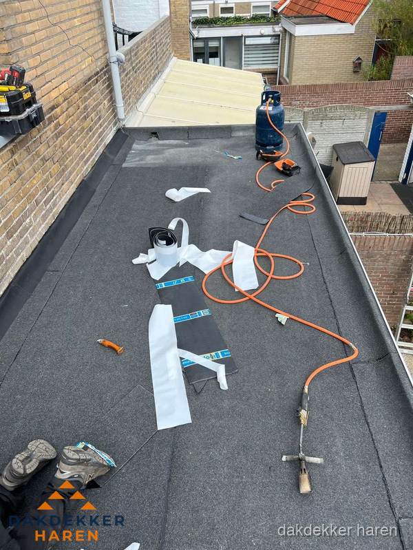 Dakdekkers bezig met bitumen dakbedekking in Haren