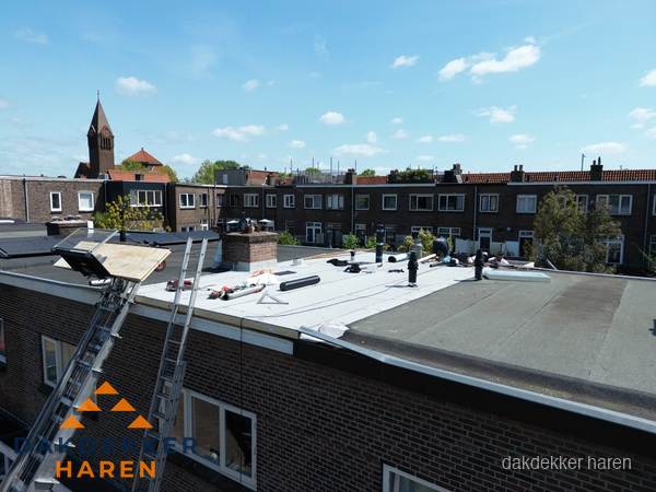 Dakdekkers aan het werk op plat dak in Haren