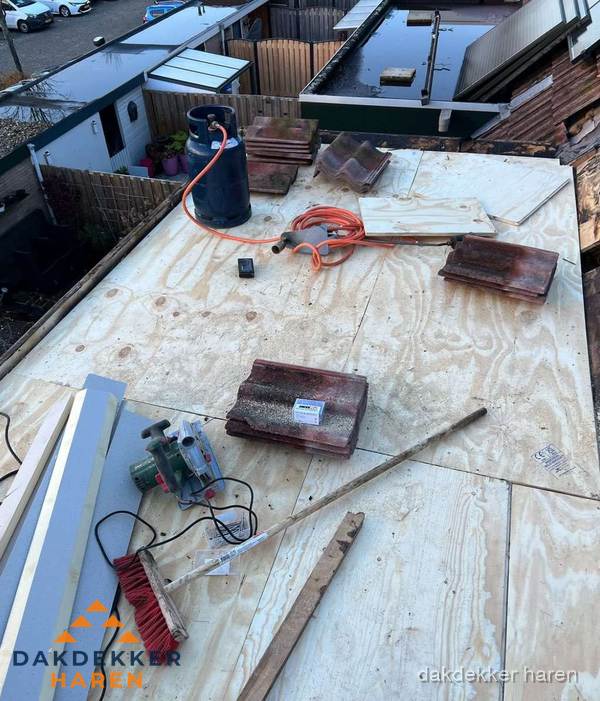 Dakreparatie werkzaamheden op plat dak met gereedschap in Haren Dakreparatie werkzaamheden op plat dak met gereedschap in Haren