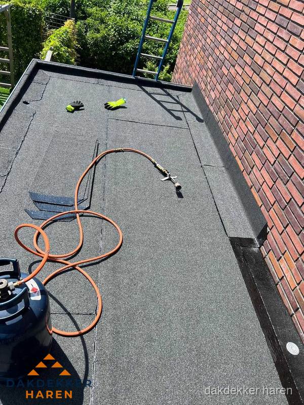 Plat dak met bitumen en brandgereedschap van dakdekkersbedrijf in Haren Plat dak met bitumen en brandgereedschap van dakdekkersbedrijf in Haren