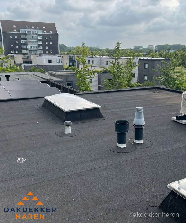 Groot plat dak met lichtkoepel en dakdoorvoeren in Haren