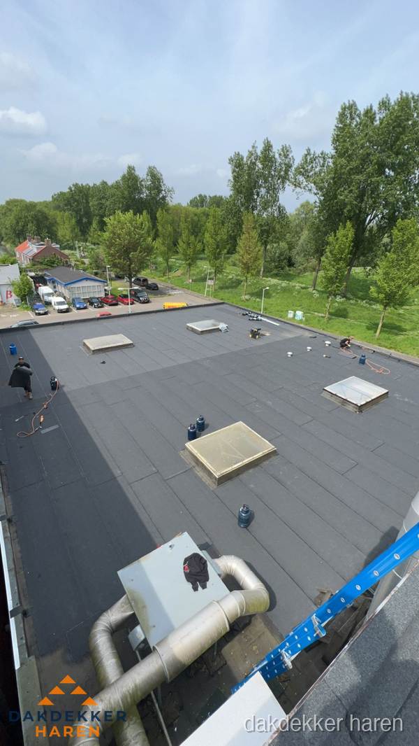Dakdekker aan het werk op groot plat dak met bitumen in Haren Dakdekker aan het werk op groot plat dak met bitumen in Haren
