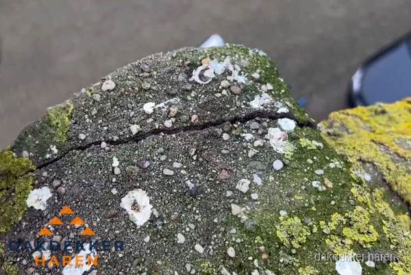 Beschadigde en verweerde nokvorst met scheuren en mos in Haren Beschadigde en verweerde nokvorst met scheuren en mos in Haren