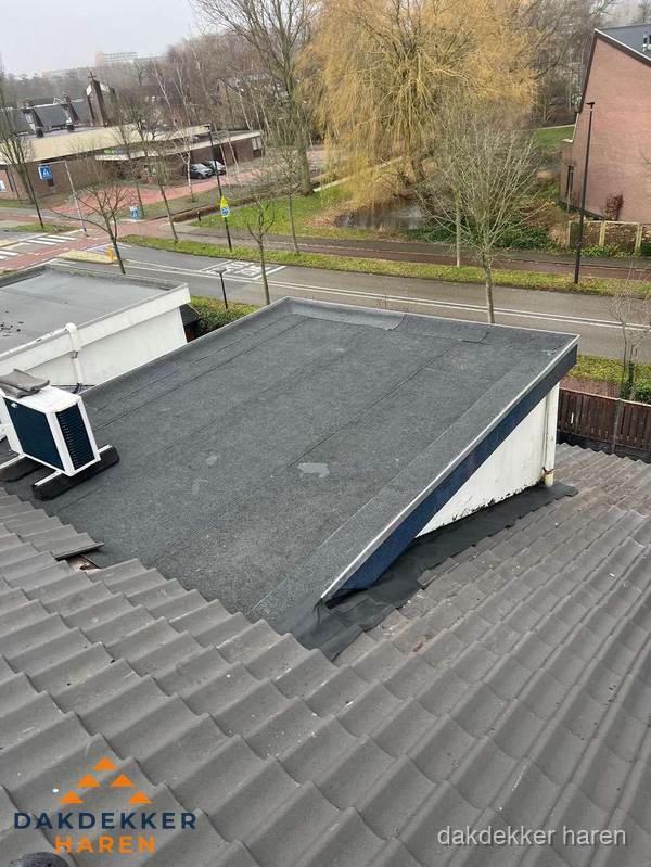 Plat dak met bitumen dakbedekking naast schuin pannendak in Haren Plat dak met bitumen dakbedekking naast schuin pannendak in Haren