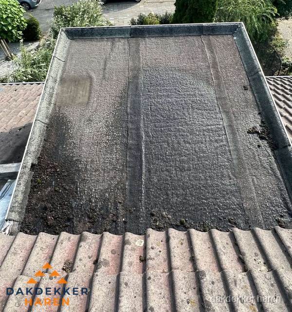 Verouderd plat dak met bitumen en slijtage voor lekkage inspectie in Haren Verouderd plat dak met bitumen en slijtage voor lekkage inspectie in Haren