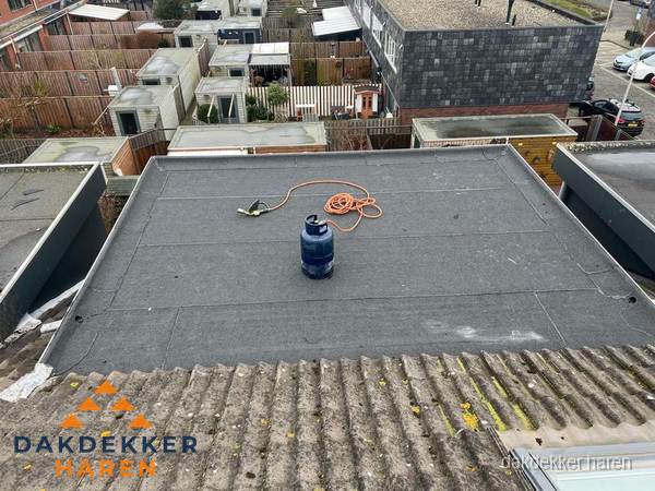 Plat dak met nieuwe bitumen dakbedekking en brandgereedschap in Haren