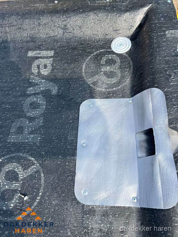 Dakdoorvoer met metalen afvoerplaat op bitumen dak in Haren