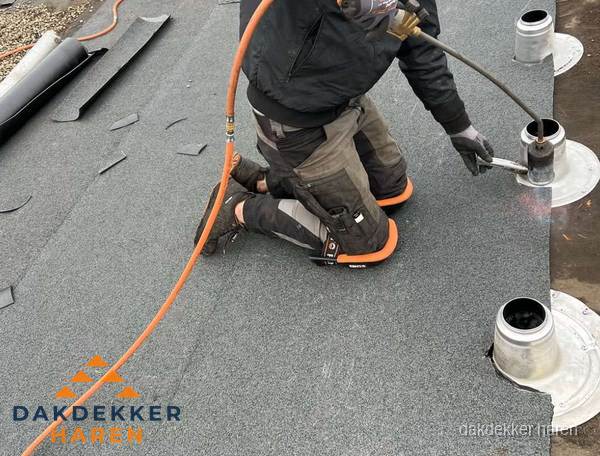 Dakdekker repareert bitumen dakleer bij dakdoorvoer in Haren Dakdekker repareert bitumen dakleer bij dakdoorvoer in Haren