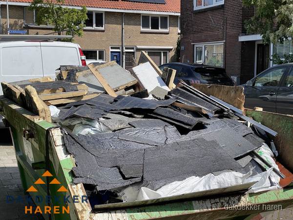Afvalcontainer met gesloopt dakmateriaal tijdens dakkapel renovatie in Haren Afvalcontainer met gesloopt dakmateriaal tijdens dakkapel renovatie in Haren