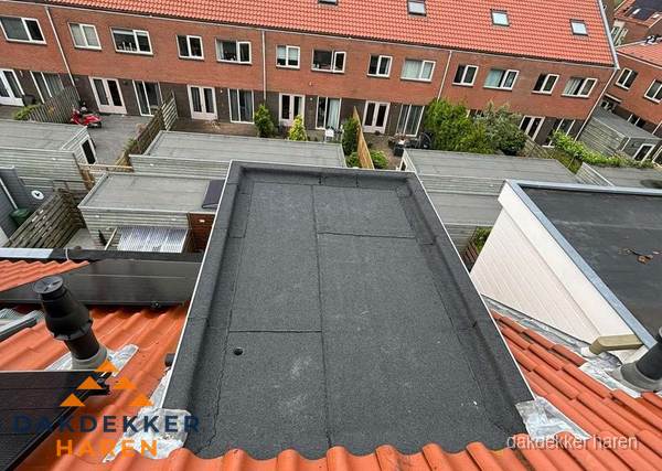 Plat dak met bitumen bedekking naast dakkapel in Haren